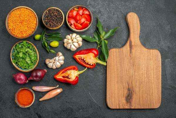 कटिंग बोर्ड पर सब्ज़ियाँ और रसोई में हल्की तैयारी का दृश्य